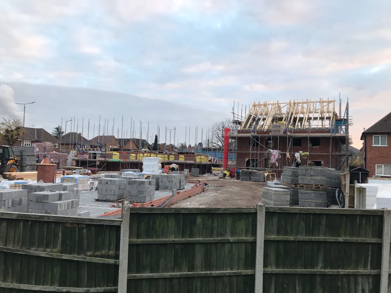 Charpentes en bois visibles sur des maisons en construction.